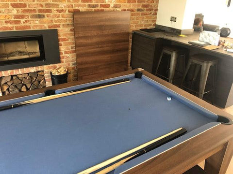 Driftwood dining top stand beside a pool dining table